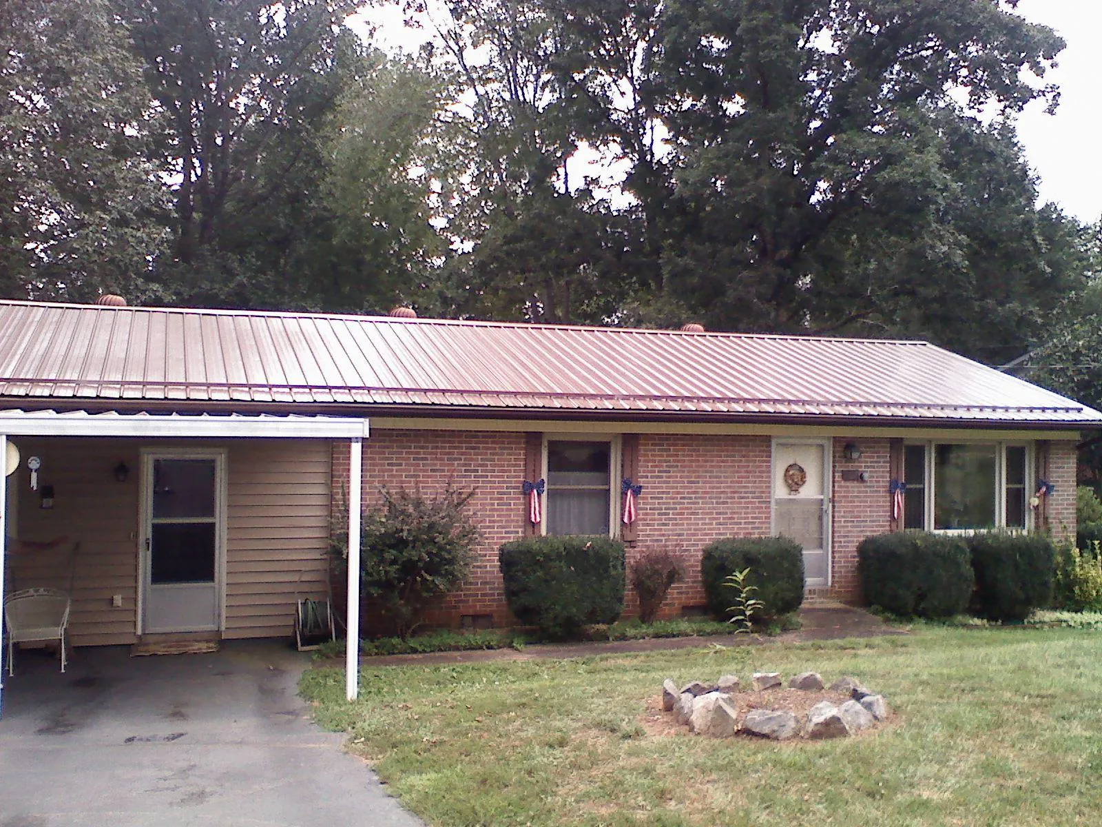 Bronze metal roof and carport on a brick ranch home — Roof Repair work by our crew in Boyers